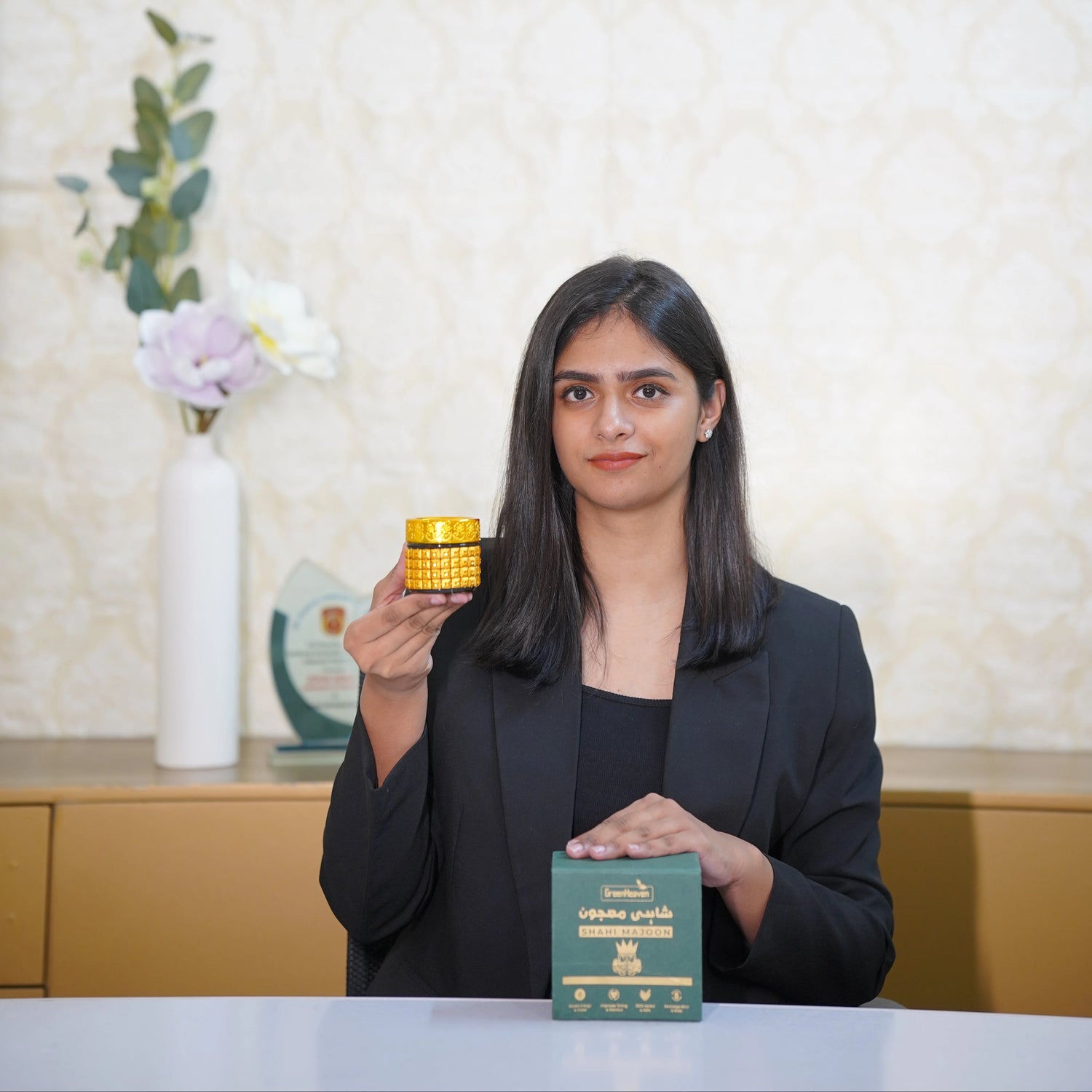Woman holding a yellow container and green box with a blurred background